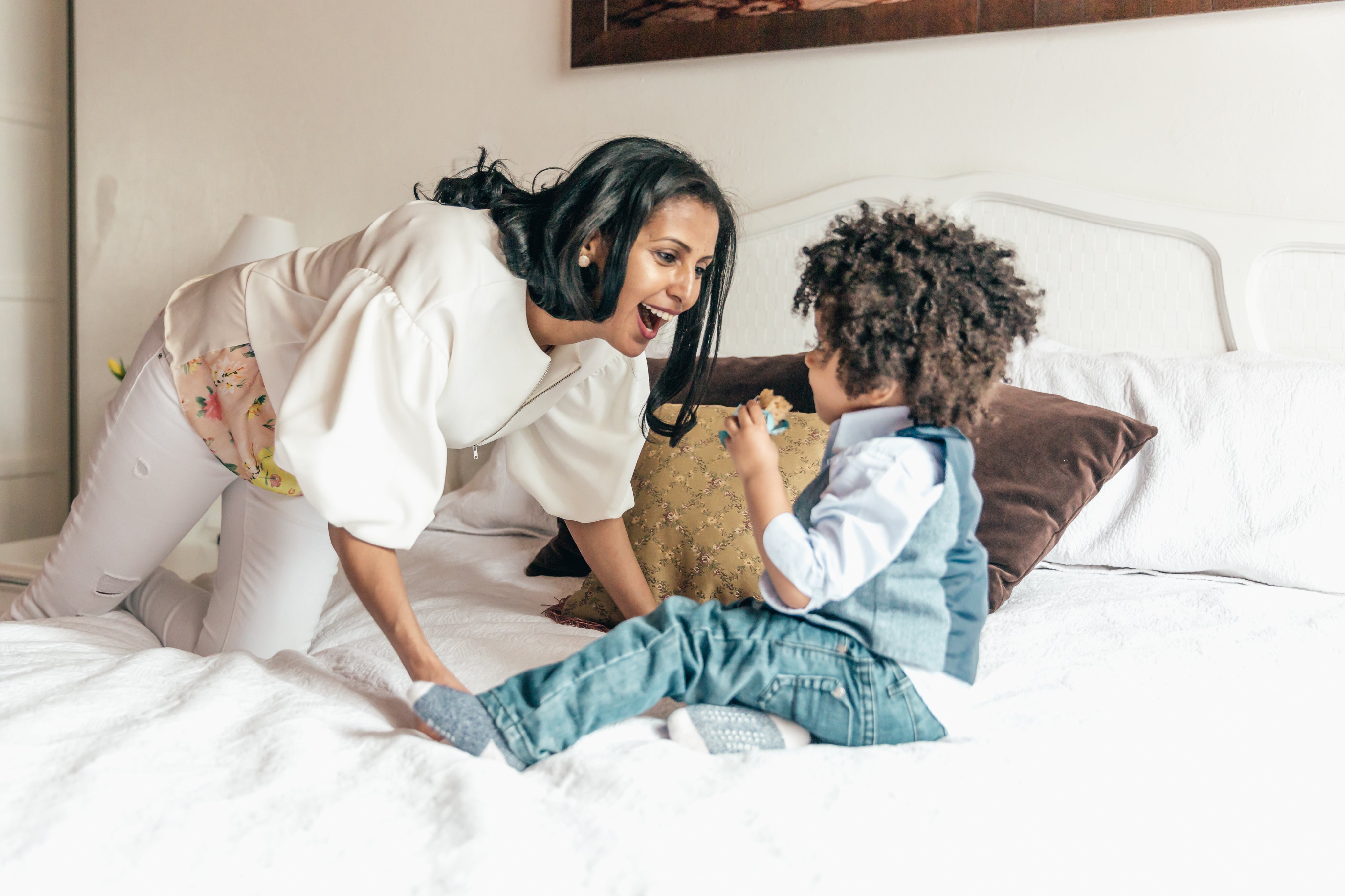 mother-playing-with-son-in-bedroom