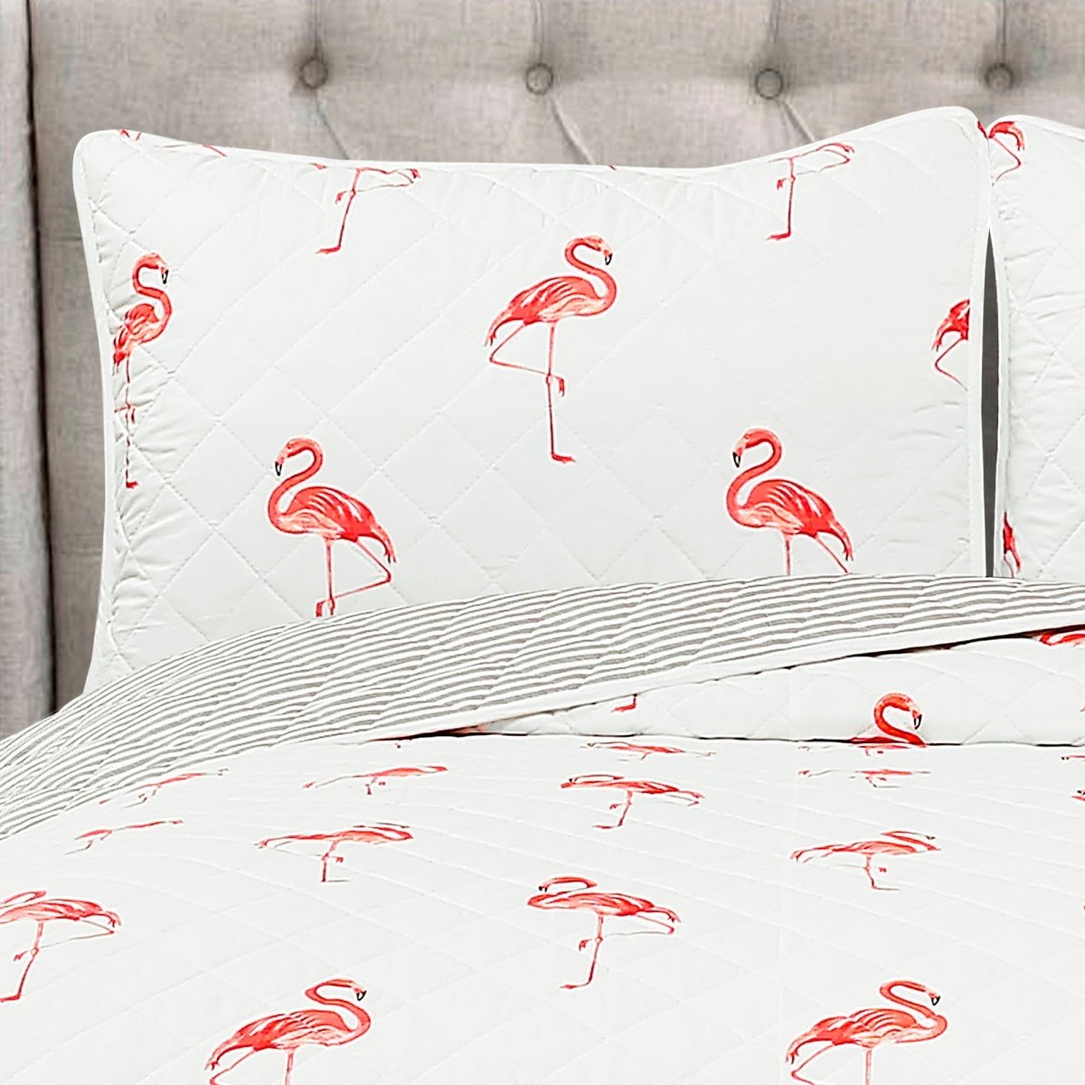 Floral-patterned pillowcases on a bed with a gray headboard.