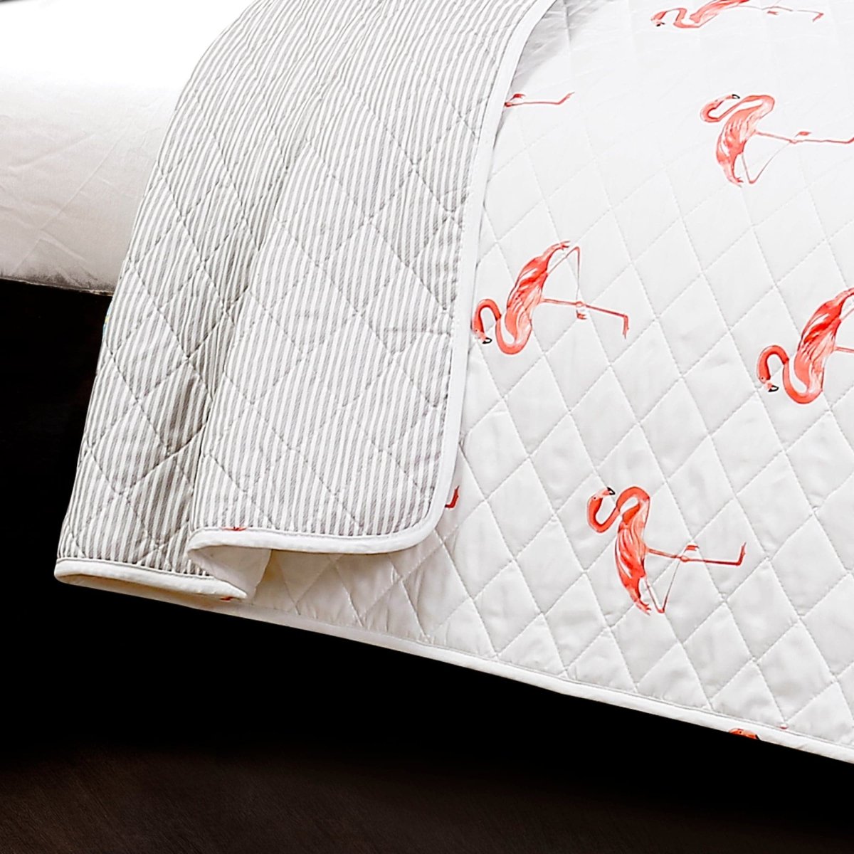 Quilt with flamingo pattern on a bed