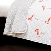 Quilt with flamingo pattern on a bed