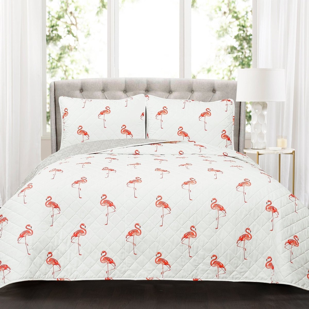 Flamingo patterned bedding set on a bed with a gray headboard.