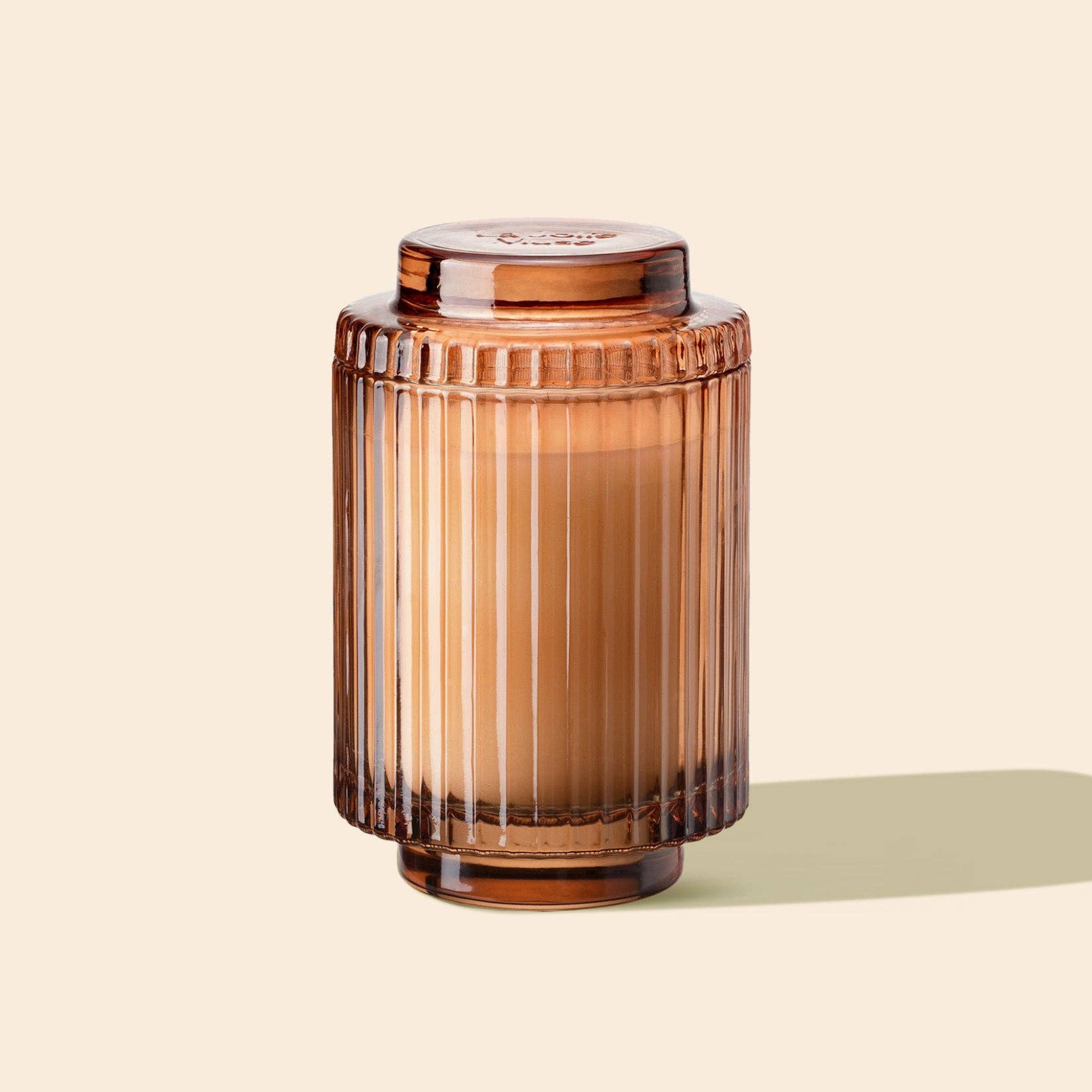 Brown glass jar with a lid on a beige background