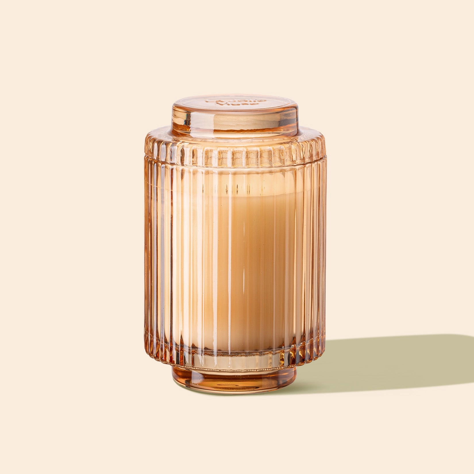 Brown glass jar with ribbed design on a beige background