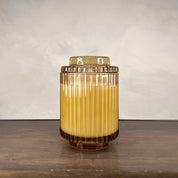 Glass container with a yellow liquid on a wooden surface