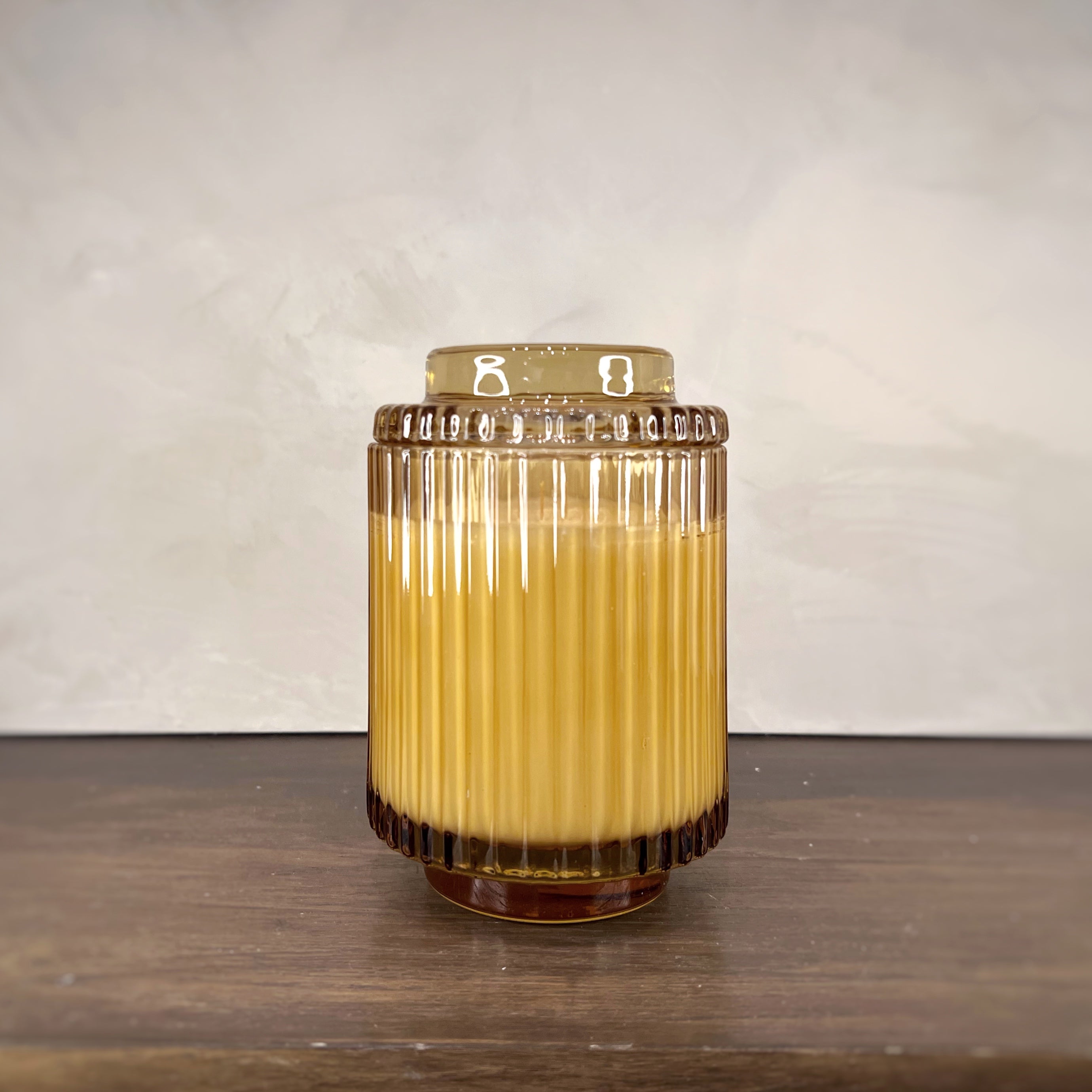 Glass container with a yellow liquid on a wooden surface