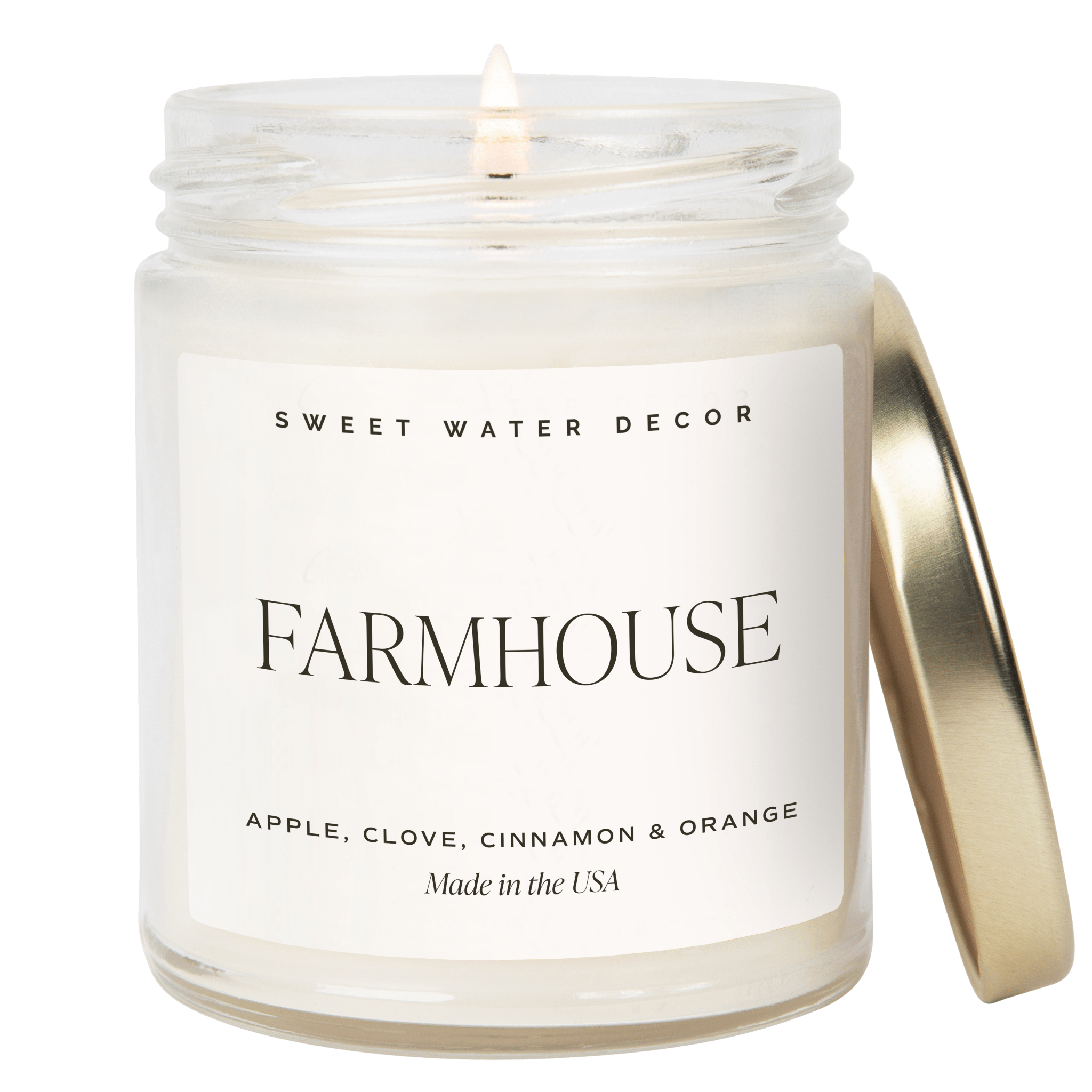 Candle in a jar labeled 'Farmhouse' by Sweet Water Decor on a green background