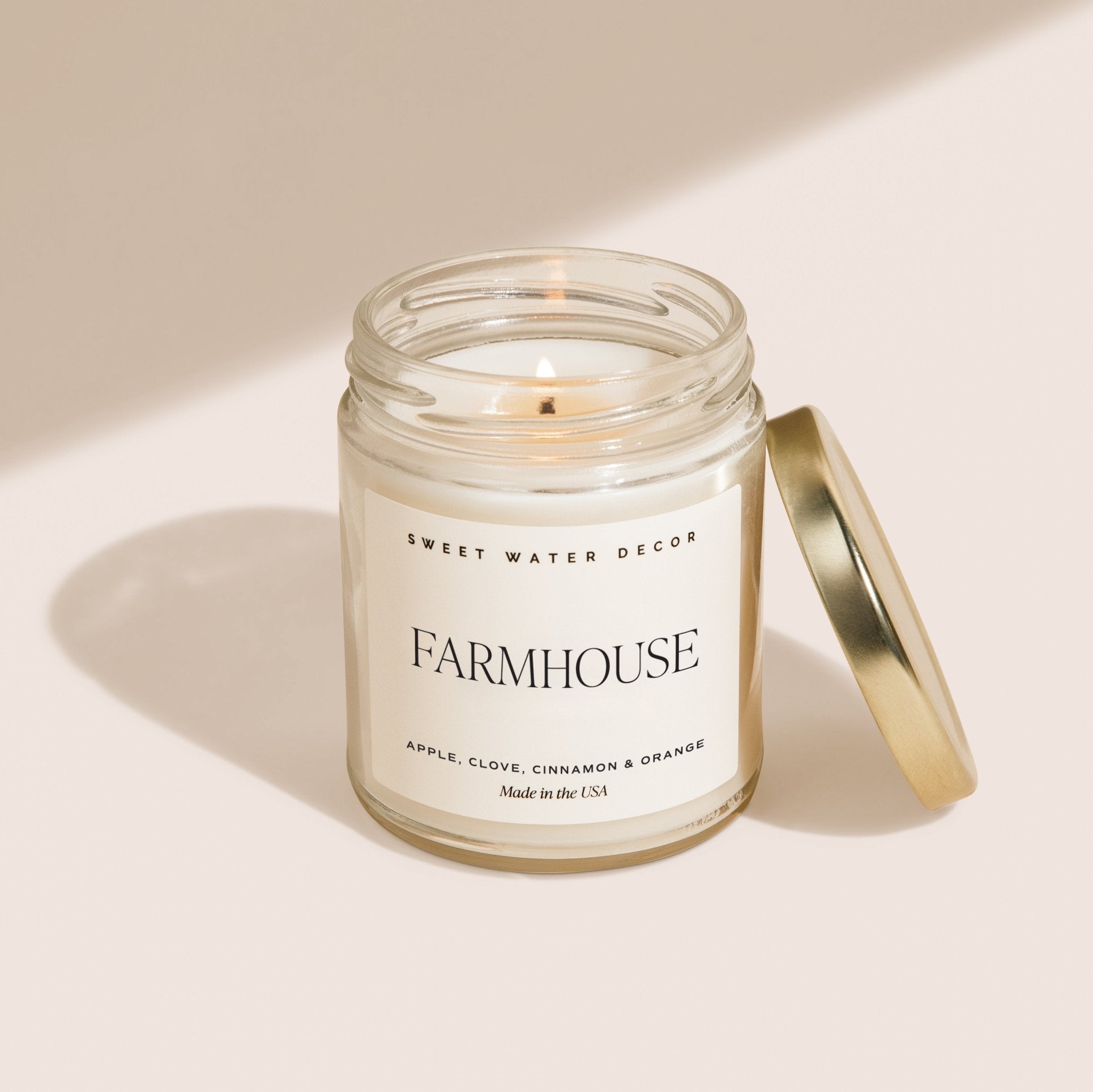 Candle in a glass jar with a label on a beige background