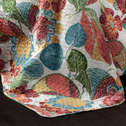 Colorful leaf-patterned quilt on a dark surface