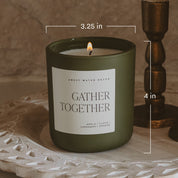 Green candle labeled 'Gather Together' with measurements on a textured surface.