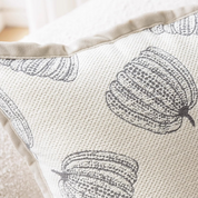 Decorative pillow with black pumpkin pattern on beige fabric