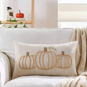 Decorative pillow with pumpkin design on a couch in a cozy living room.
