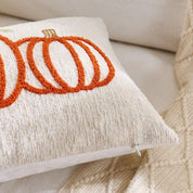Decorative pillow with orange pumpkins on a beige couch