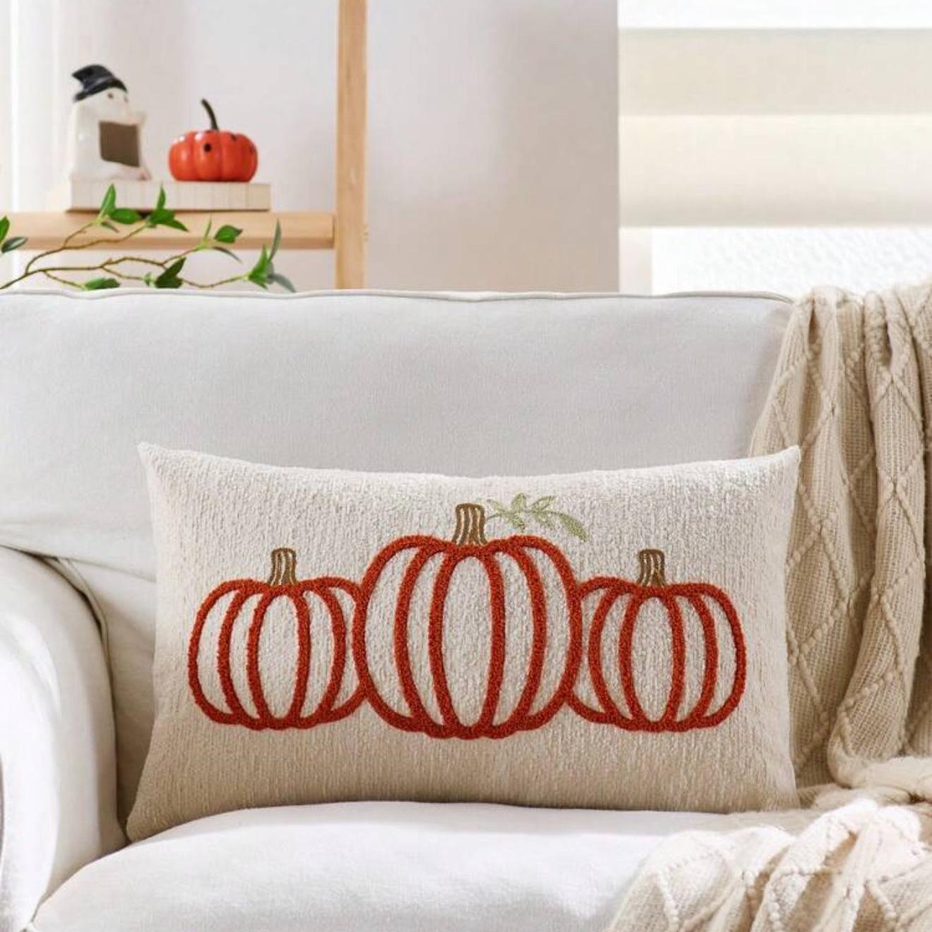 Decorative pillow with red pumpkins on a white couch