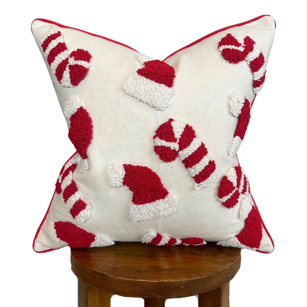 Decorative pillow with red and white candy cane pattern on a wooden stool