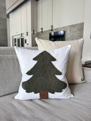 Decorative pillow with a tree design on a couch in a living room setting.