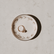 Decorative ring dish with a ring on a light gray surface