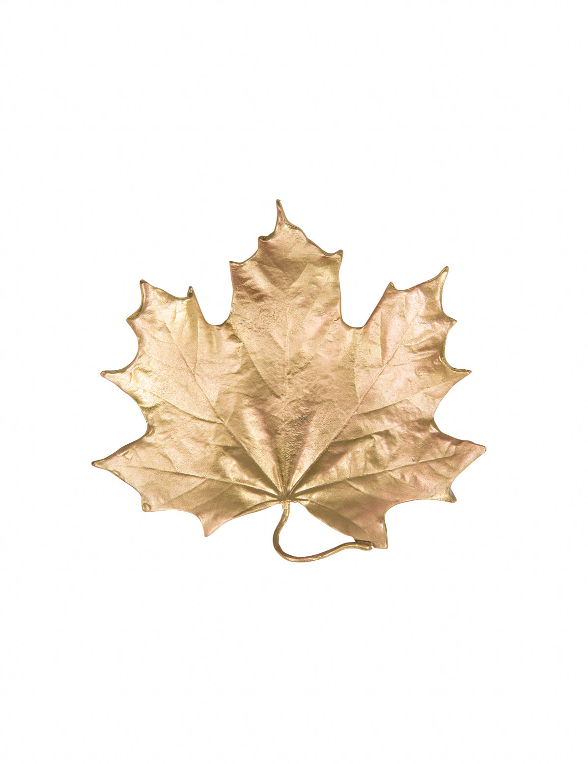 A gold-colored forged metal dish shaped like an maple leaf against a white background.