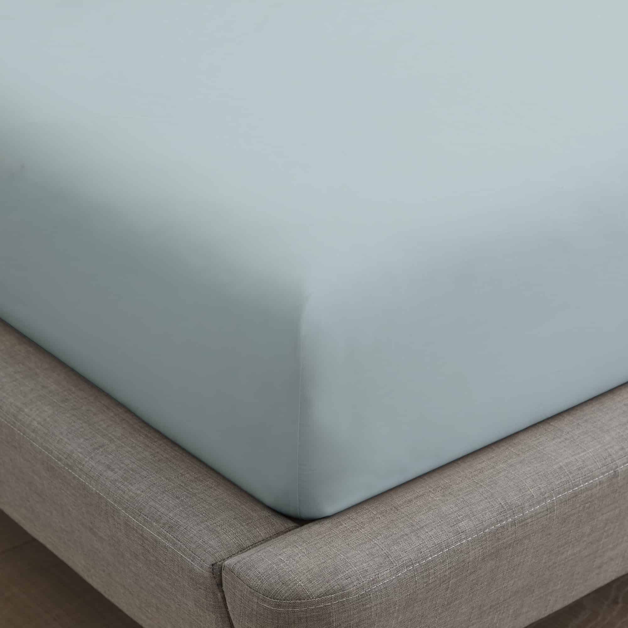Light blue fitted sheet on a bed with a gray frame