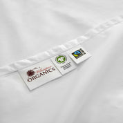 Close-up of a white fabric with a label featuring 'My Wholesome Organics' branding on a white background.