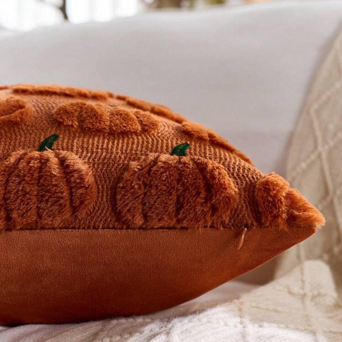 Brown textured pillow with pumpkin design on a white surface