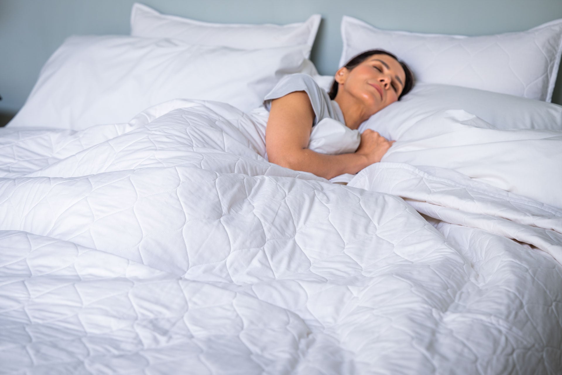 Woman_under_Covers_Color_White_Quilted_Bedspread_100_Cotton_Made_in_USA.jpg