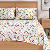 Christmas-themed bedspread with festive patterns on a bed in a bedroom setting.