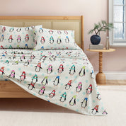 Bed with penguin-themed bedding in a bedroom setting