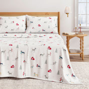 Bedding set with animal pattern on a bed in a room with a lamp and table.