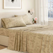 Beige floral-patterned bedspread on a neatly made bed in a bedroom setting.