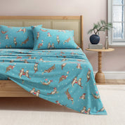 Bed with blue patterned bedding and pillows in a bedroom setting.