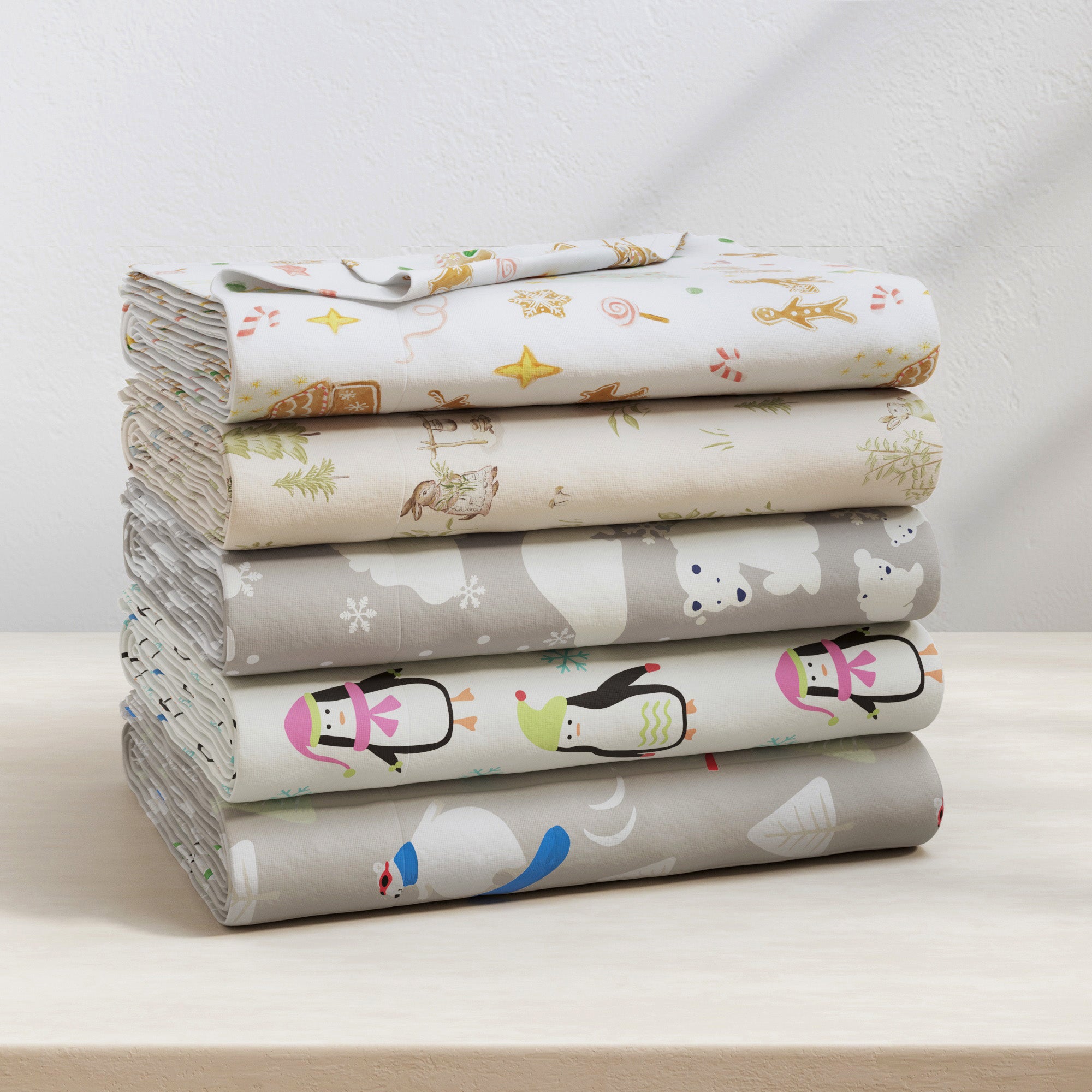 Stack of folded fabric sheets with animal patterns on a light surface.
