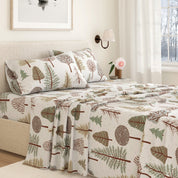 Bed with forest-themed bedding in a bedroom setting