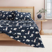 Navy blue bedding set with polar bear pattern on a bed in a bedroom.