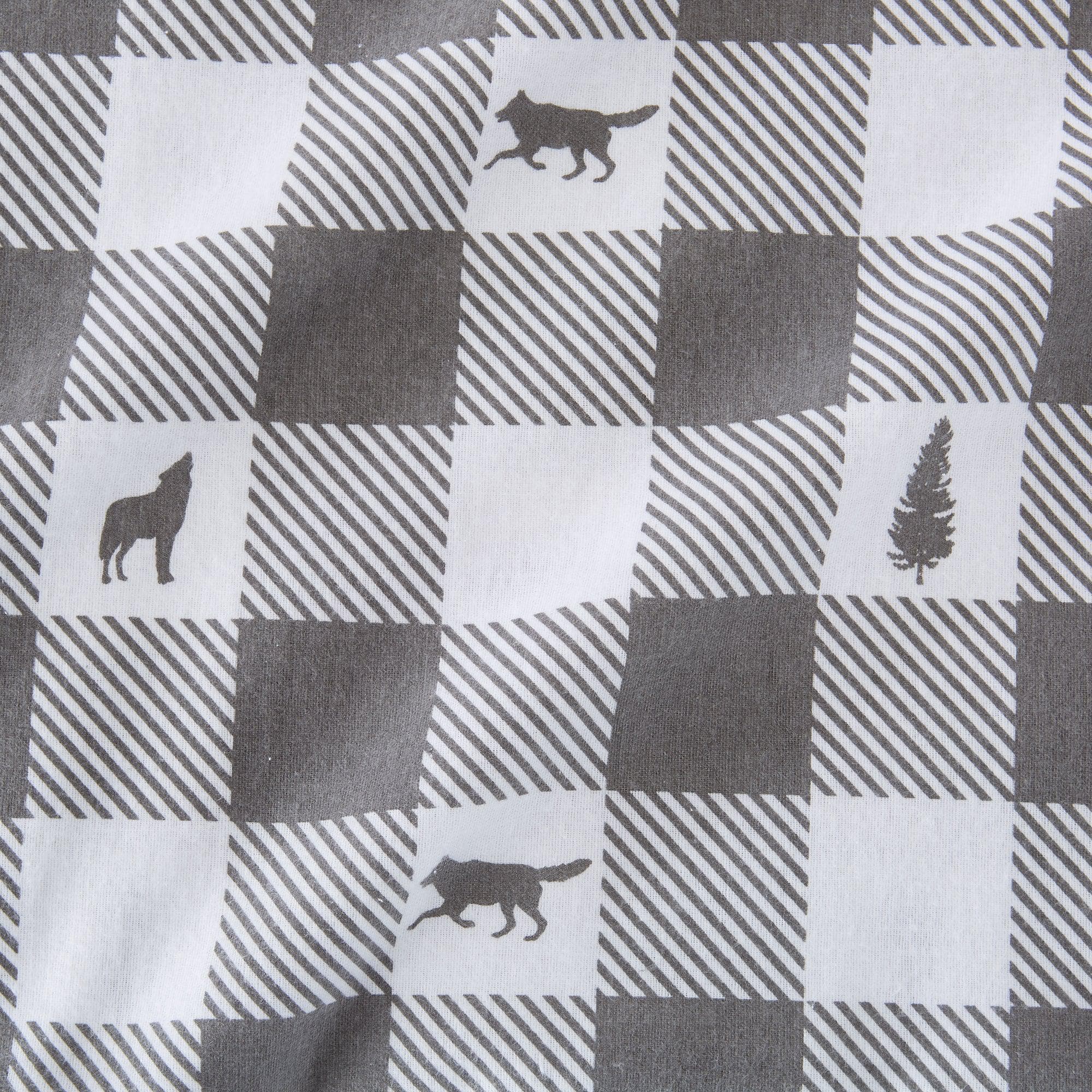 Checkered fabric with wolf and tree silhouettes on a gray and white background