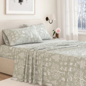 Bed with green patterned bedding in a bedroom setting