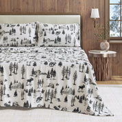 Bed with black and white nature-themed bedding in a bedroom setting.