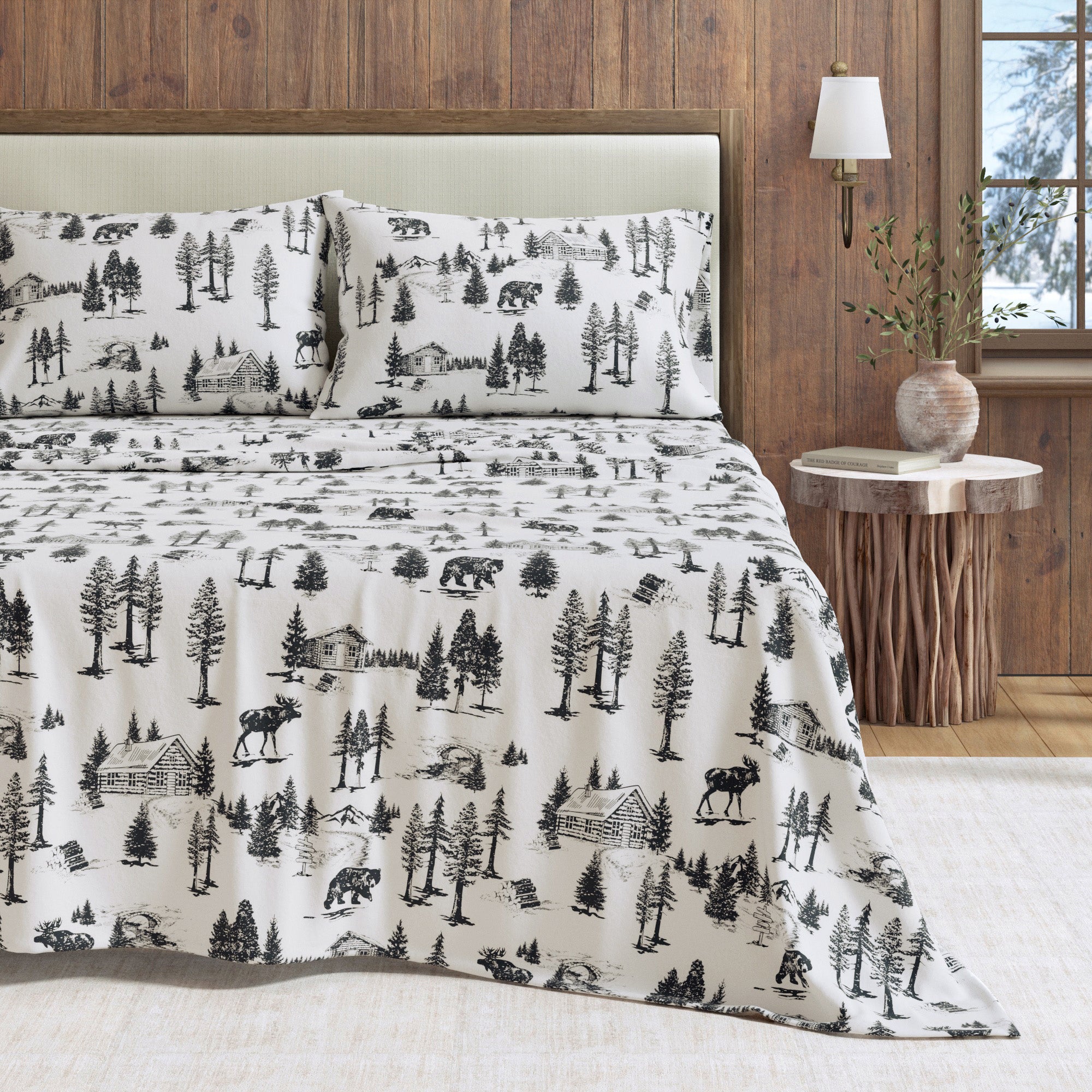 Bed with black and white nature-themed bedding in a bedroom setting.