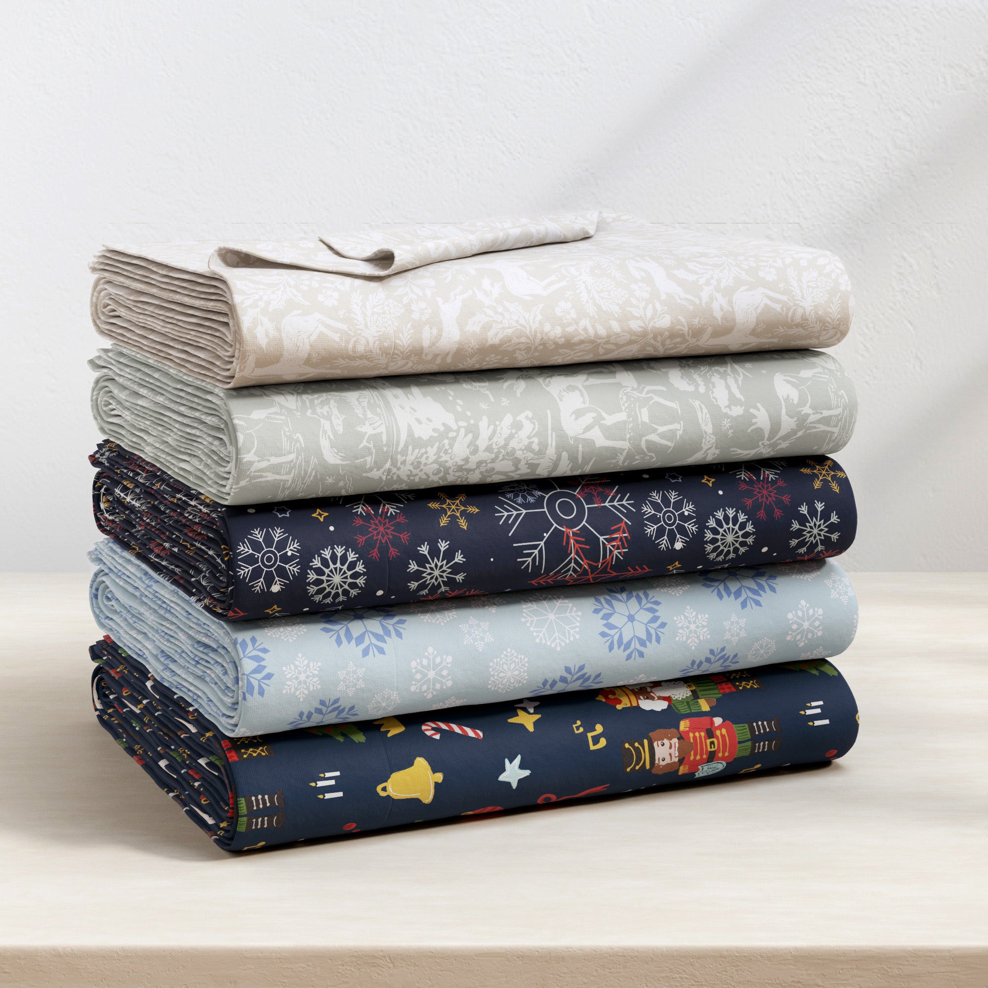 Stack of folded fabric with various patterns on a light surface.