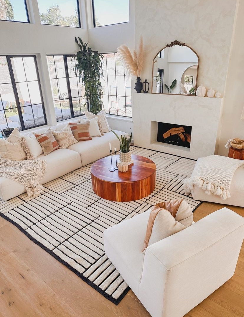 Modern living room with white sofas, a wooden coffee table, and a fireplace.
