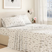 Neatly made bed with floral-patterned bedding in a bedroom setting.