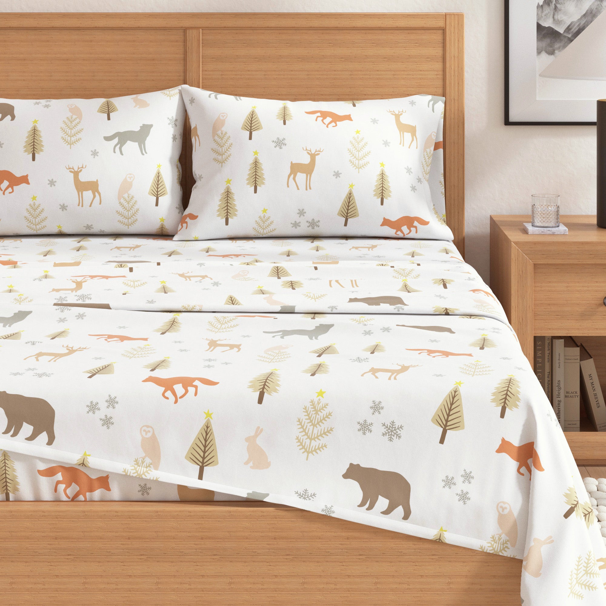 Bed with forest-themed bedding featuring animals and trees on a white background.