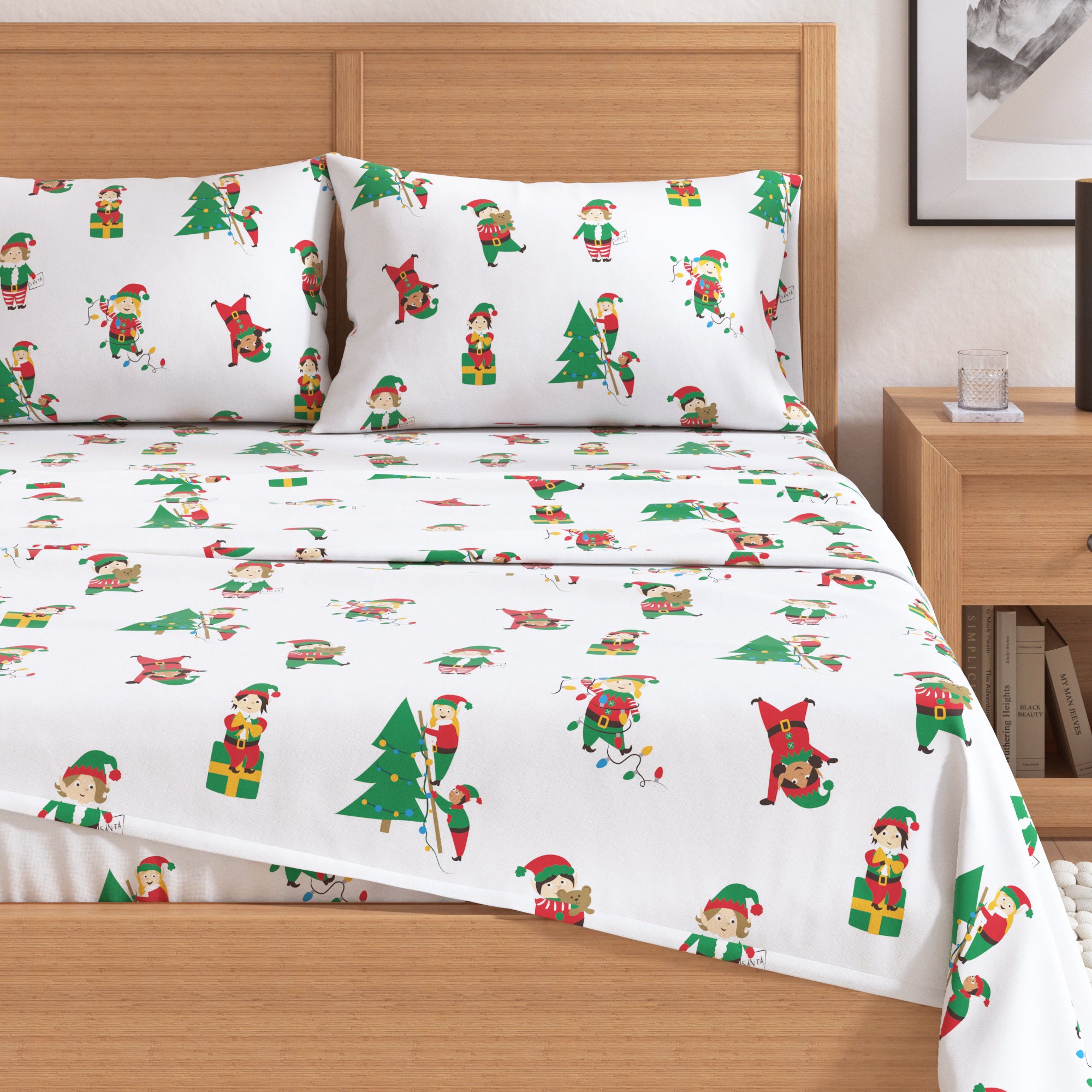 Christmas-themed bed sheet set with elves and trees on a wooden bed.