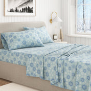 Bed with blue floral patterned bedding in a bright bedroom.