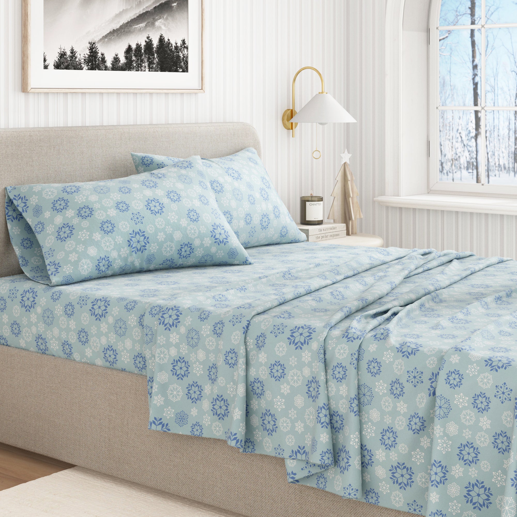 Bed with blue floral patterned bedding in a bright bedroom.