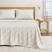 Floral patterned bedspread on a bed with a wooden headboard and side table.