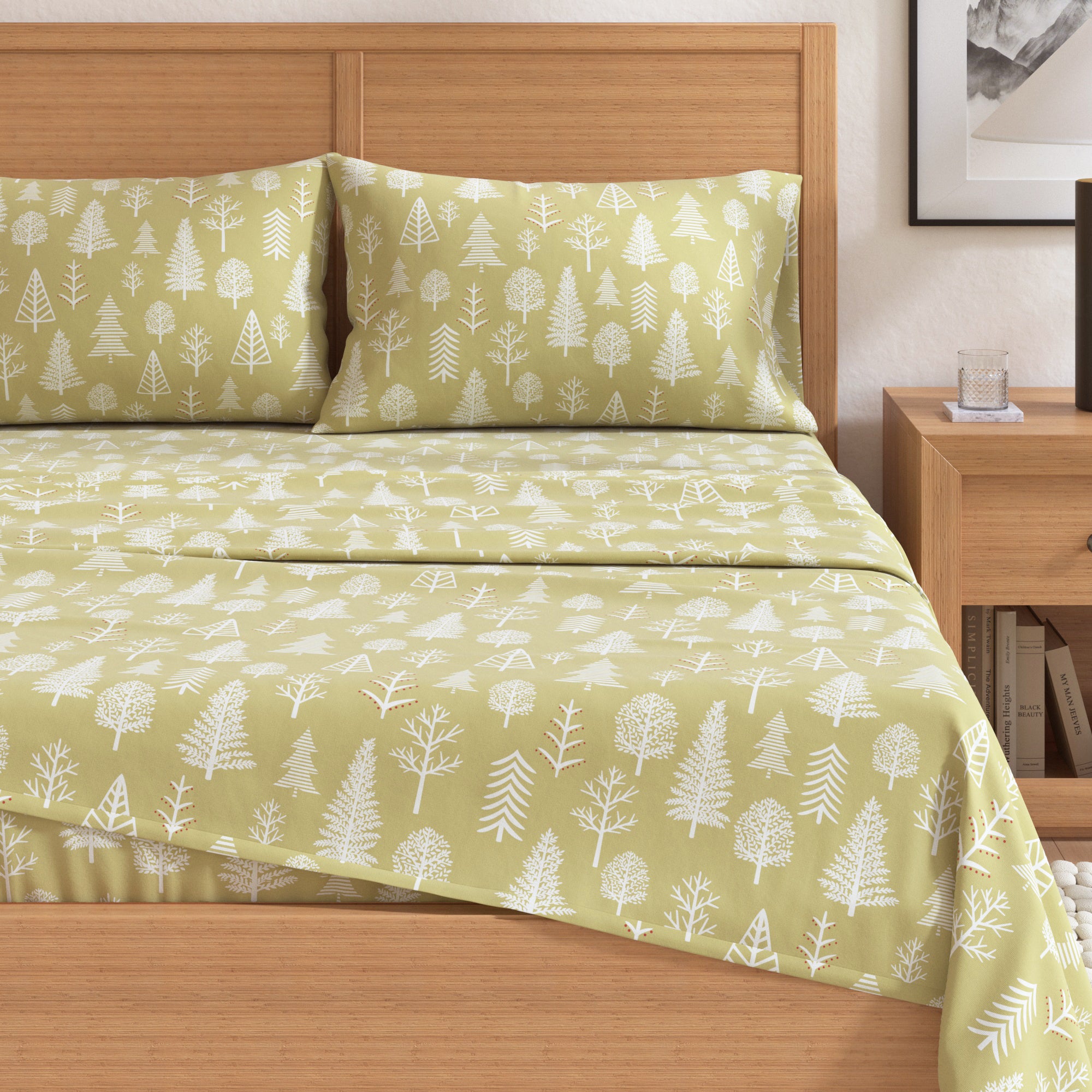 Green bedspread with white tree pattern on a wooden bed in a bedroom setting.