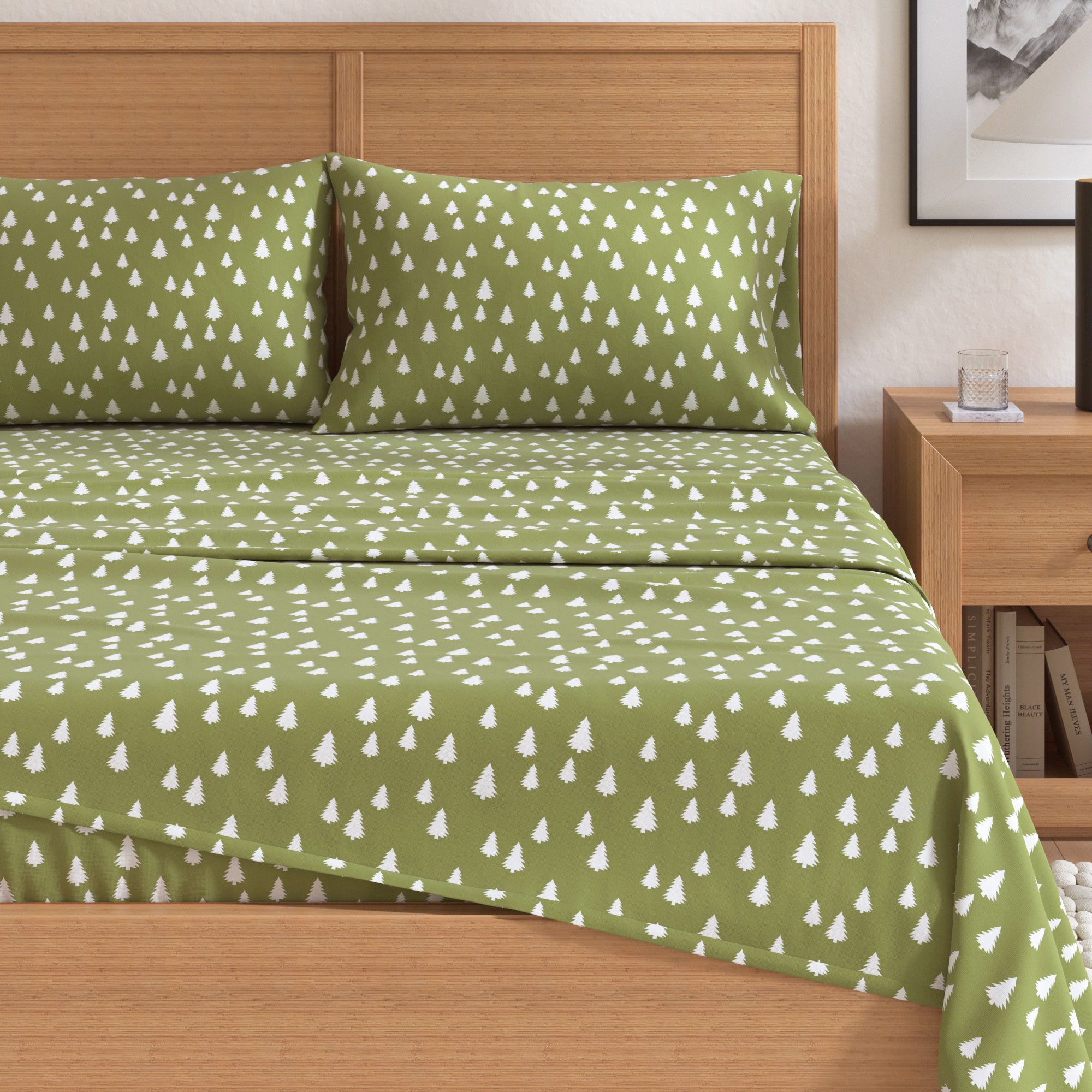 Green bedspread with white tree pattern on a wooden bed in a bedroom setting.