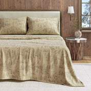 Beige patterned bedspread on a bed with pillows in a bedroom setting.