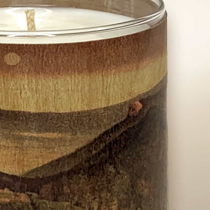 Close-up of a candle with a wooden design on the glass