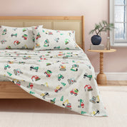 Bed with colorful construction vehicle patterned bedding in a bedroom setting.